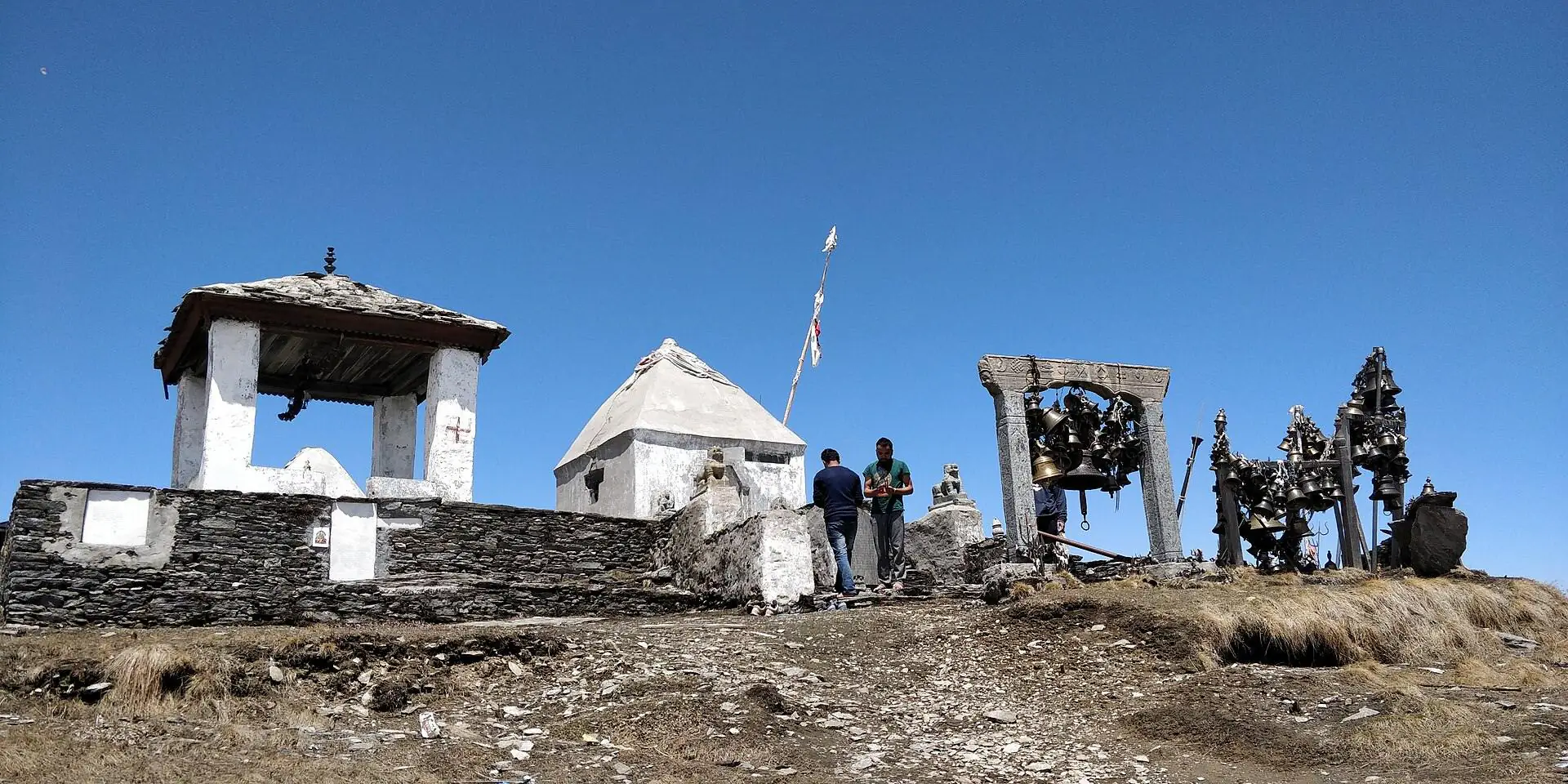 Badimalika Temple complex with its stone shrines and hanging bells